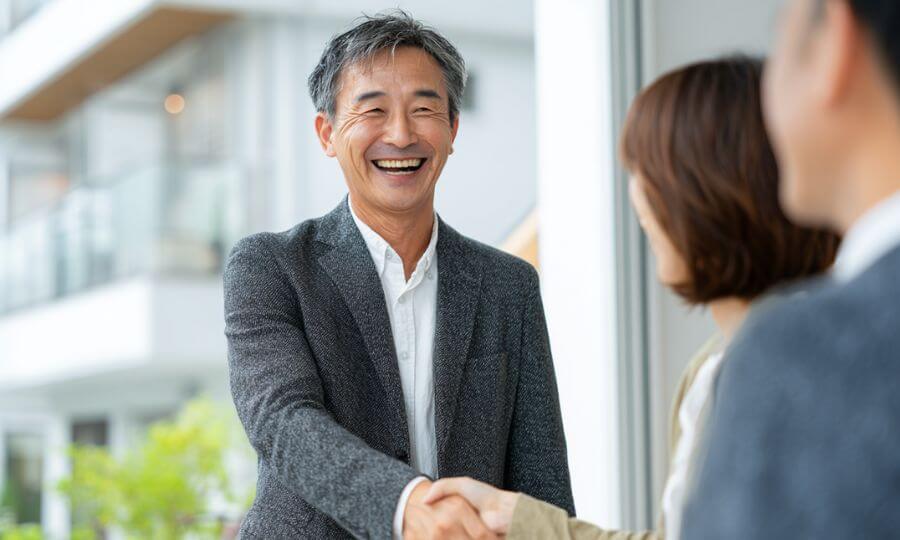 管理会社と握手する笑顔の賃貸物件オーナー